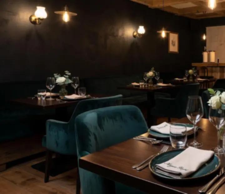 Hangulatos, gyertyafényes bistro terem elegáns rendezvényterítéssel